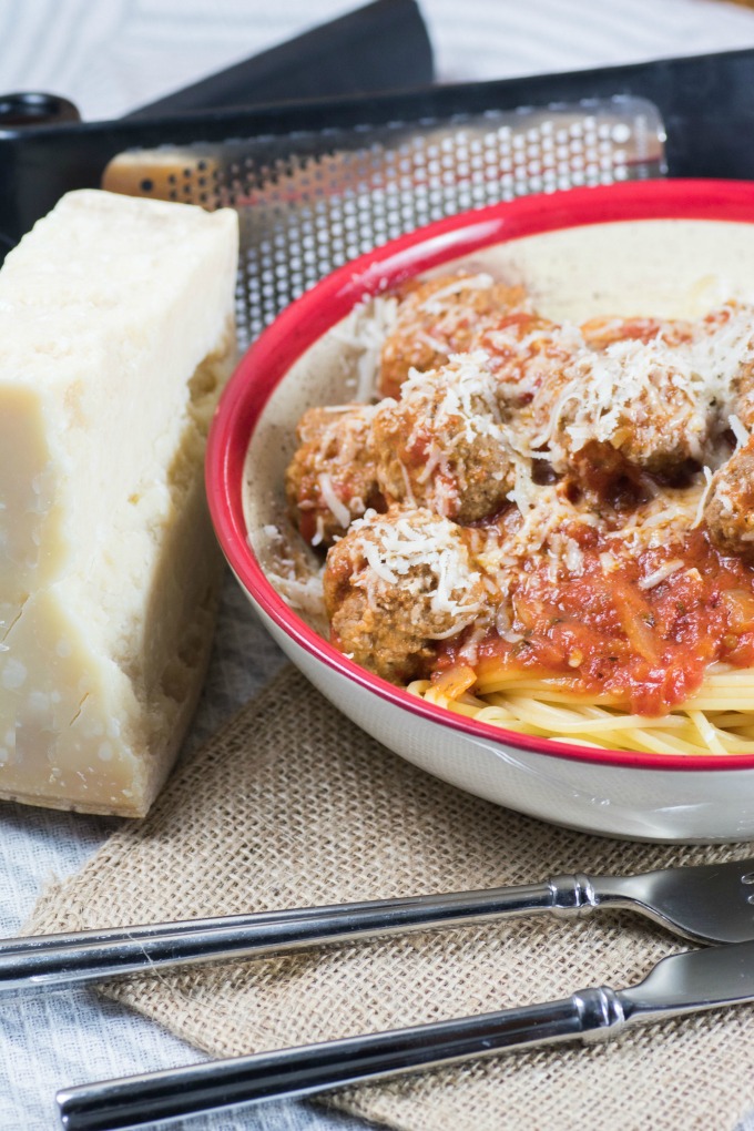 Spaghetti and Meatballs in Marinara Sauce is easy to make with the right recipe! This one will be your new family favorite. #spaghetti #meatballs #marinarasauce Spaghetti and Meatballs in Marinara Sauce in a bowl with a fork and knife and Parmesan cheese