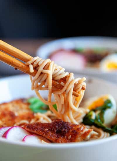 Wrapping noodles around chopsticks from a bowl of ramen.