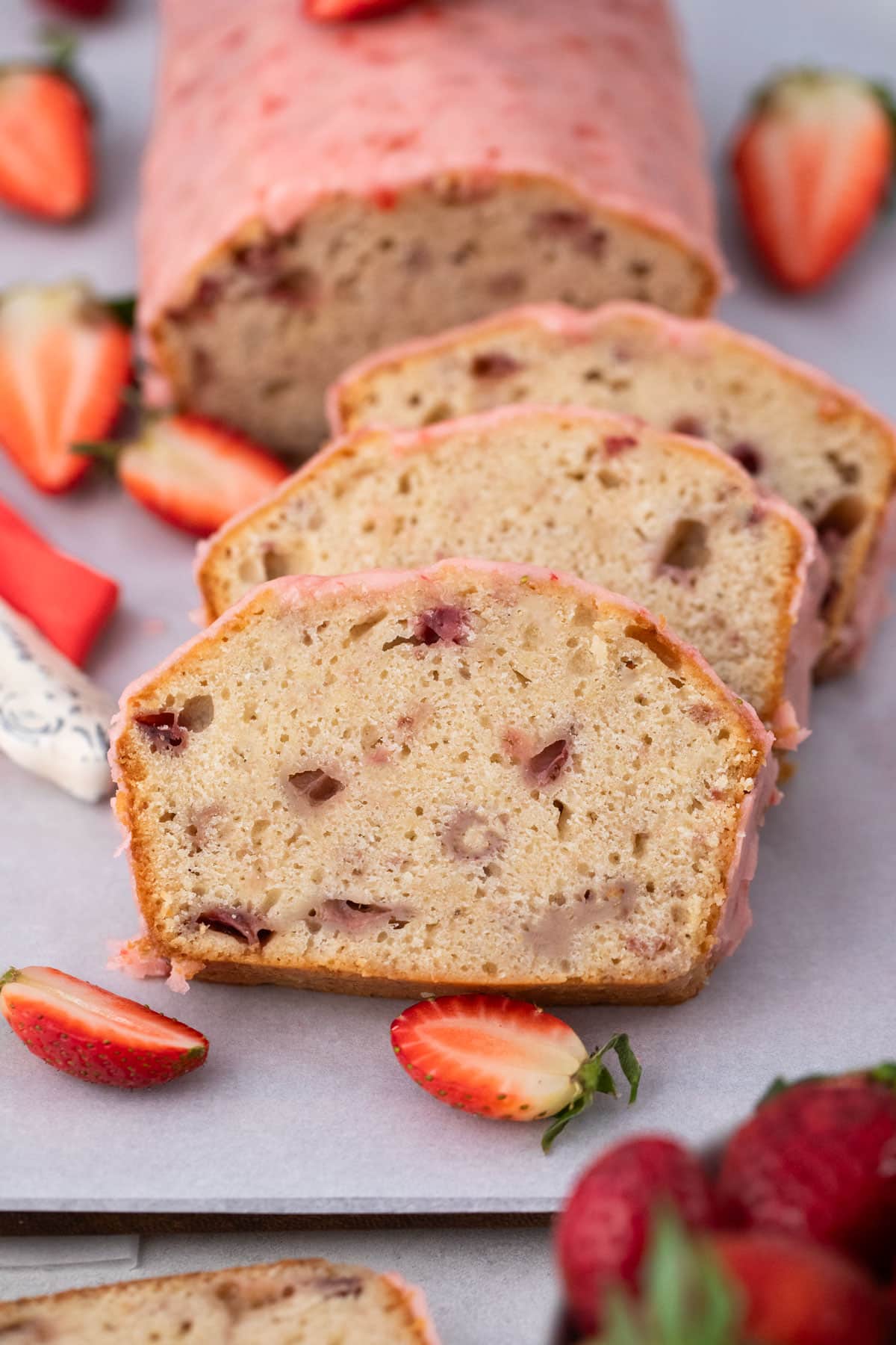 Strawberry Pound Cake is the perfect spring/summer dessert that is great at any time of the day. Strawberry flavor bursts from this luscious cake and will become a favorite. Showing slices of strawberry pound cake.